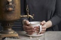 Side view of female hands pouring cup of tea from vintage samovar and jar of homemade jam, tea party concept Royalty Free Stock Photo