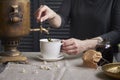 Side view of female hands pouring cup of tea from vintage samovar and jar of homemade jam, tea party concept Royalty Free Stock Photo