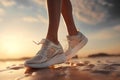 side view of female legs of a girl runner in running net lace up sneakers, shoes close-up on wet sandy beach. Running woman on sea Royalty Free Stock Photo