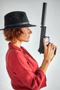 Side view on female posing with gun against white background Royalty Free Stock Photo