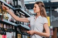 side view of female shop assistant with bottle of wine Royalty Free Stock Photo