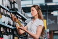 side view of female shop assistant with bottle of wine Royalty Free Stock Photo