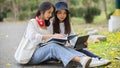 Side view of female students outdoor studying together, reading books at the park in university Royalty Free Stock Photo