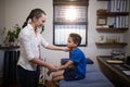 Side view of female therapist examining boy on bed