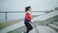 Side view of fit young woman running up stairs. Female athlete running up the steps. Royalty Free Stock Photo