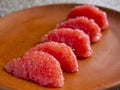 Side view of five pieces of peeled grapefruit