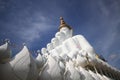 Side view of Five white buddha statues sitting well alignment in front of blue sky