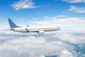 Side view of a flying passenger plane on clouds