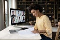 Focused smiling young African American woman holding video call.