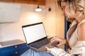 Side view of focused young woman businesswoman freelancer holding open grey laptop, looking at screen, typing at home. Royalty Free Stock Photo