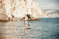 Side view foto of a man swiming and relaxing on the sup board. Sportive man in the sea on the Stand Up Paddle Board SUP Royalty Free Stock Photo