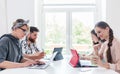 Dedicated young people sharing a desk while telecommuting