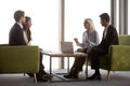 Side view four diverse businesspeople negotiating sitting on cou