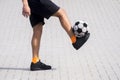 Side view of freestyle soccer or futsal player juggling ball wit
