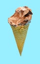 side view of fresh chocolate flavor ice cream cone with some bites on a blue background Royalty Free Stock Photo