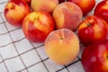 side view of fresh ripe nectarines and peaches on plaid fabric background Royalty Free Stock Photo