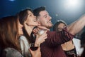 Side view. Friends taking selfie in beautiful nightclub. With drinks in the hands Royalty Free Stock Photo