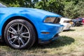 Side view of a front of a blue Ford Mustang