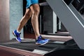Side view full length of young man in sportswear running on treadmill at gym Royalty Free Stock Photo