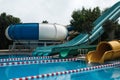 Side view of fun slides in aquapark. Summer vacation entertainment ideas. Colorful slide variety and turquoise swimming pool at a