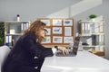 Side view of a funny strange male office worker working on laptop sitting at desk in office.