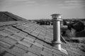 Side view of a Galvanized metal chimney exhaust on asphalt roof with a rain cap