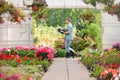 Side view of gardener carrying crate with flower pots while walking outside greenhouse