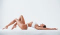 Side view of girl that lying down. Beautiful woman with slim body in underwear is in the studio Royalty Free Stock Photo