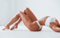 Side view of girl that lying down. Beautiful woman with slim body in underwear is in the studio Royalty Free Stock Photo