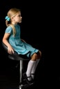 Side view of girl sitting on high chair Royalty Free Stock Photo