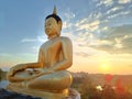 Side view Golden Buddha statue against sunset sky in Thailand temple Royalty Free Stock Photo