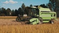 Side view of a Green Modern Combine Harvester In A Wheat Field Ready To Harvest Royalty Free Stock Photo