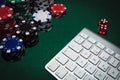 Side view of a green poker table with some poker cards on a keyboard. Betting on-line concept Royalty Free Stock Photo