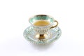 Side view of green and white teacup and saucer with tea