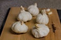Side View Group Of Garlic Cloves Up Close On A Wooden Chopping Board