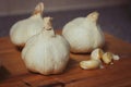 Side View Group Of Garlic Cloves Up Close Wooden Chopping Board