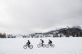 Side view of group of mountain bikers riding outdoors in winter. Royalty Free Stock Photo