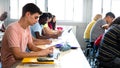 Side view of group of multiracial high school students studying and using laptops in class. Royalty Free Stock Photo