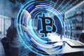 Side view of hacker hands using computers at desktop with creative glowing bitcoin hologram and map on blurry office interior Royalty Free Stock Photo