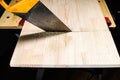 Side view of hand saw sawing solid wooden board Royalty Free Stock Photo