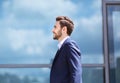 Side view of handsome businessman in front of office building in modern megapolis Royalty Free Stock Photo