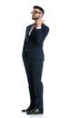 Businessman standing with hand in pocket one way pointing behind Royalty Free Stock Photo
