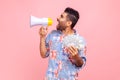 Side view of handsome crazy screaming in megaphone man with beard holding fan of dollars, wearing Royalty Free Stock Photo