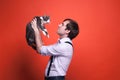 Handsome man in shirt with rolled sleeves holding over face cute gray and white cat and looking at it muzzle Royalty Free Stock Photo