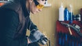 Side view of handsome mechanic using electric circular saw in his busy workshop. Bright sparks, professional tools and Royalty Free Stock Photo