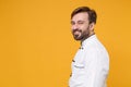 Side view of handsome young bearded male chef cook or baker man in white uniform shirt posing isolated on yellow Royalty Free Stock Photo