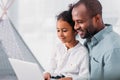 side view of happy african american father and daughter using laptop Royalty Free Stock Photo