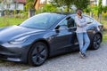 Confident African woman standing in front of her electric car Royalty Free Stock Photo