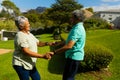Side view of happy biracial senior couple holding hands and dancing in park during sunny day Royalty Free Stock Photo