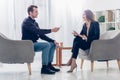 Side view of happy businesswoman in suit giving interview to journalist Royalty Free Stock Photo